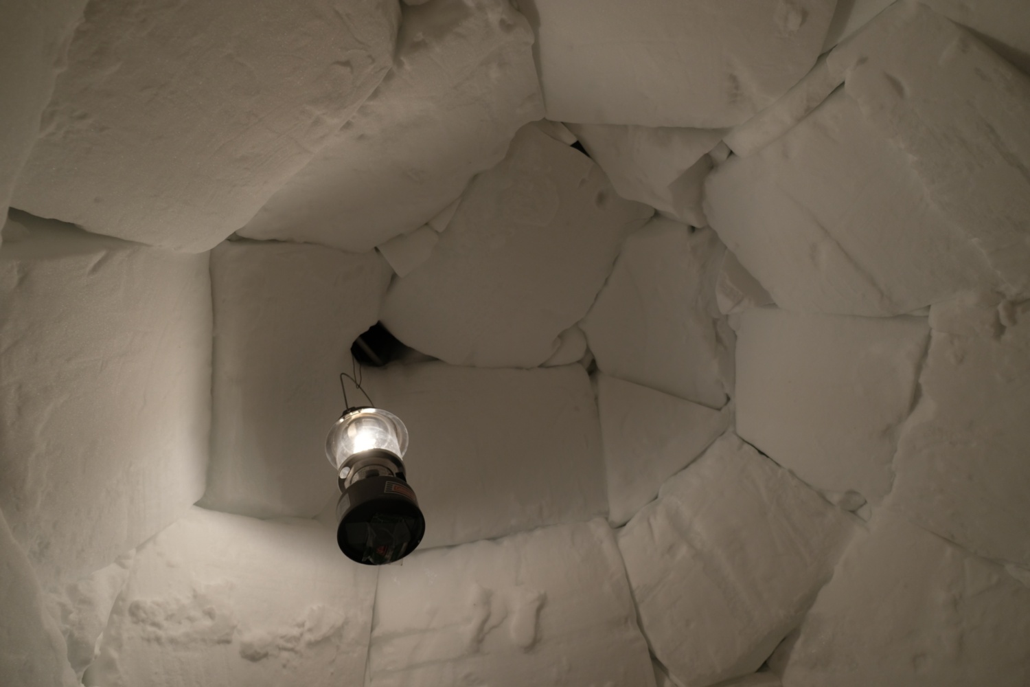 A lantern hung from the ceiling of the igloo.