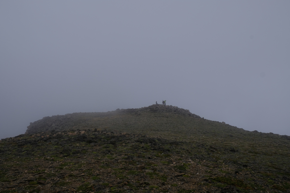 People on the summit of Mt Oxford in the fog.