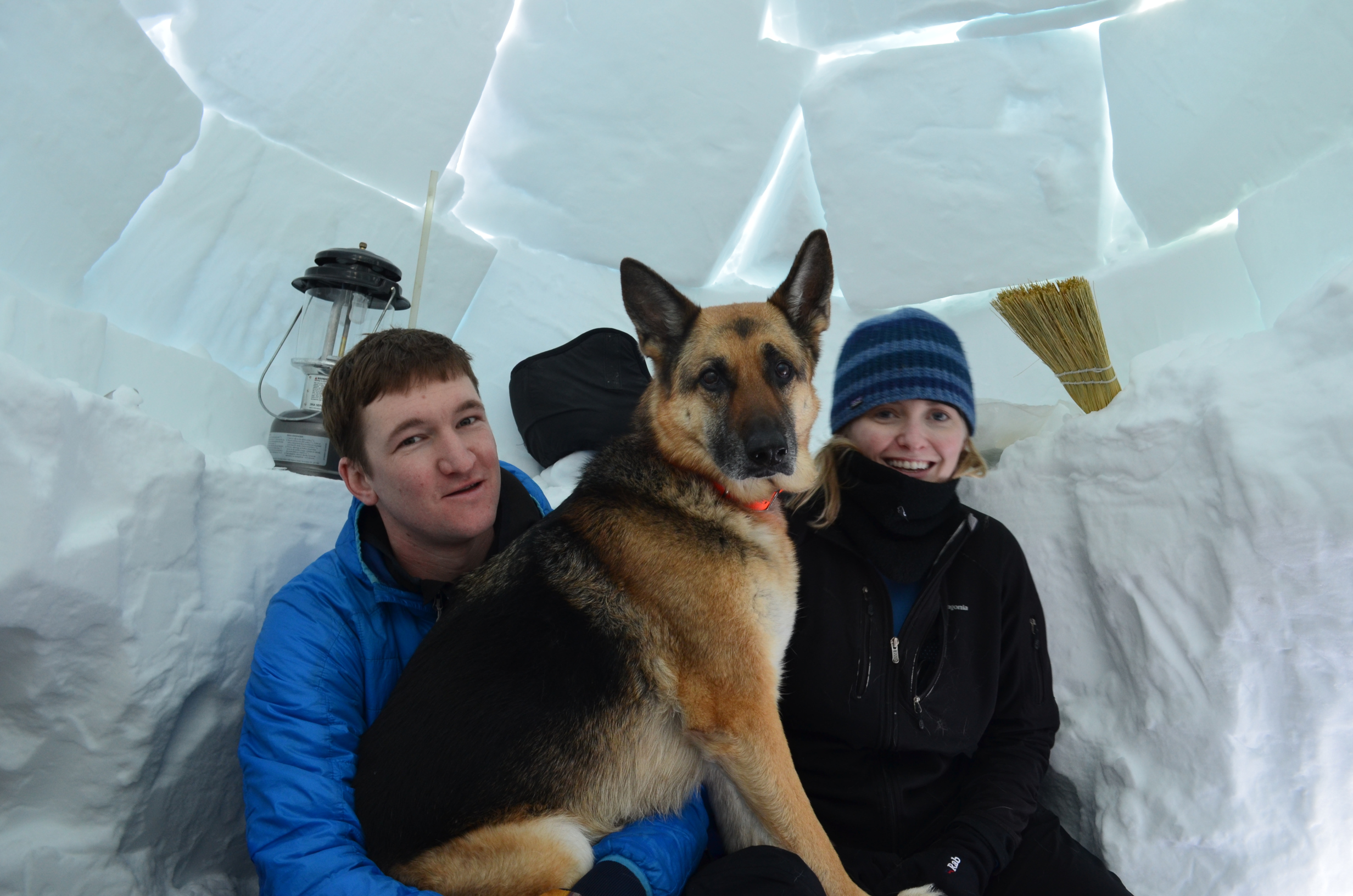 2 visitors and their dog, inside the igloo.
