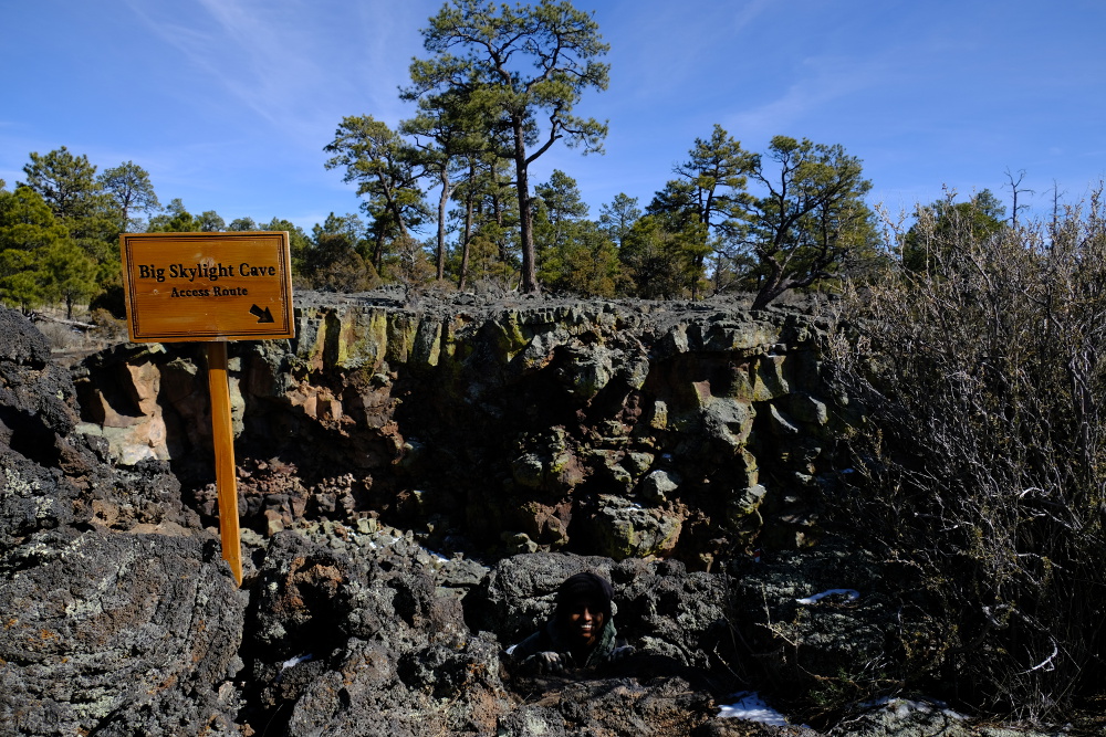 Eshani hiding near the cave access route sign.