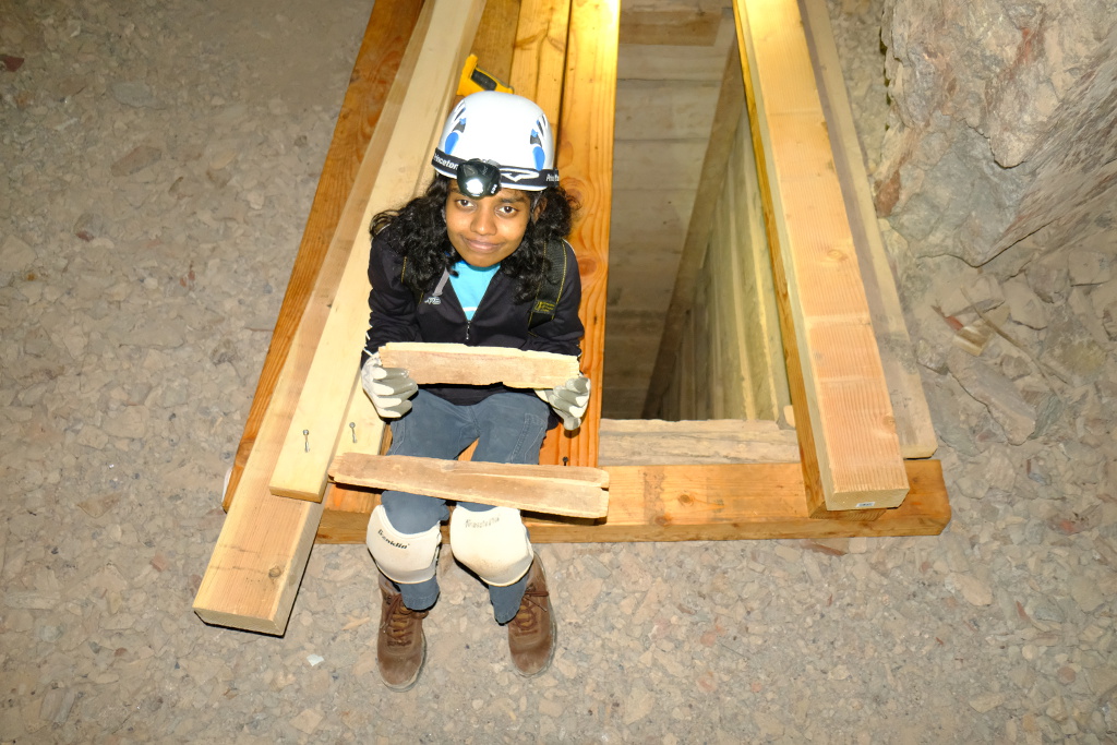 Eshani holding part of an old dynamite box.