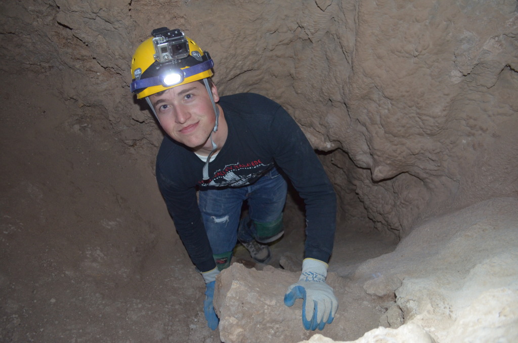 Caver climbing up a slope.