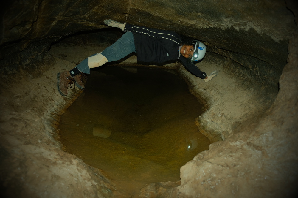 Chimneying over a pool in Millrace Cave.