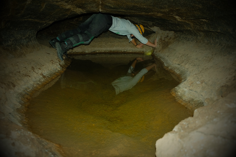 Chimneying over a pool in Millrace Cave.