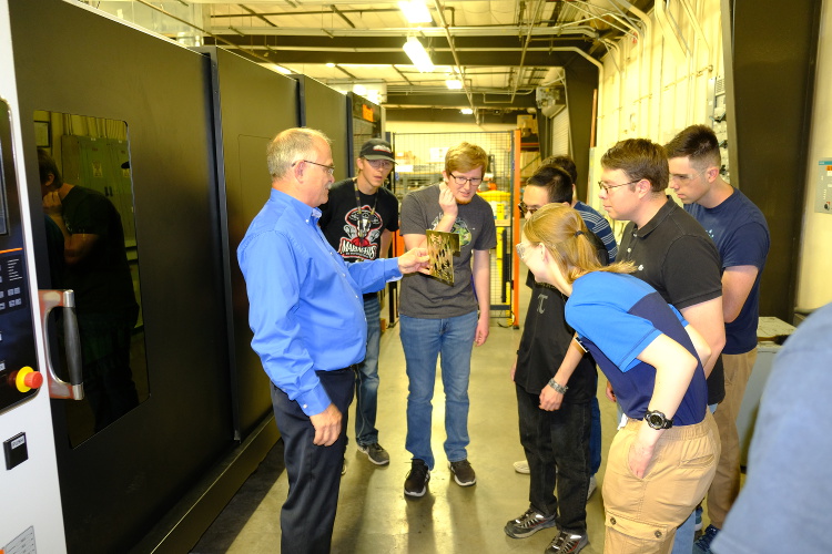 Students examining metal cut by the laser cutter.