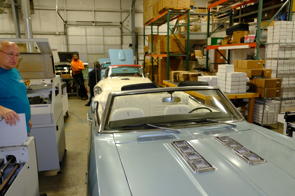 Several antique cars inside building 3.